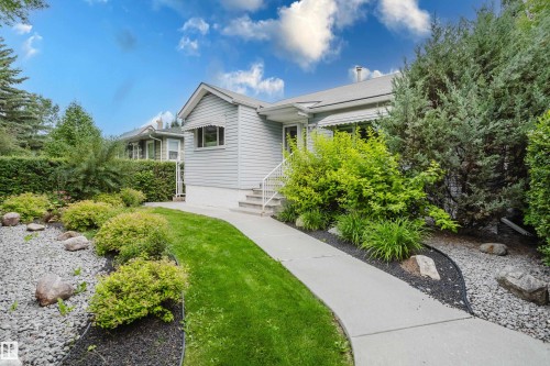Exterior featuring light gray siding, white window awnings, and a concrete pathway - 14814 104 Avenue Nw, Edmonton, AB - Outdoor