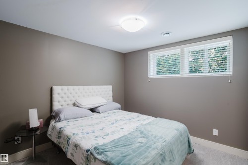 Carpeted room featuring neutral wall tones, white trim, and a flush-mount ceiling light - 14814 104 Avenue Nw, Edmonton, AB - Indoor Photo Showing Bedroom