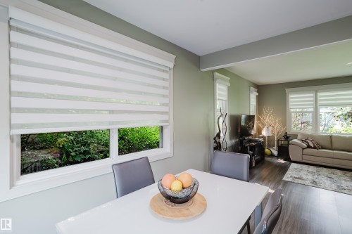 Bright dining area featuring a white rectangular table with a glossy finish - 14814 104 Avenue Nw, Edmonton, AB - Indoor Photo Showing Living Room