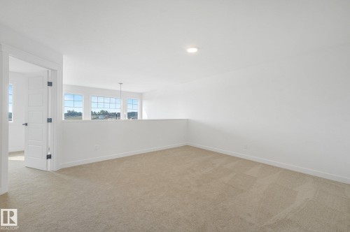 Upper-level landing with neutral carpeting and recessed lighting - 511 157 Avenue Ne, Edmonton, AB 