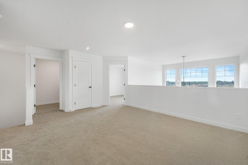 Bright loft space featuring a light-colored carpet, recessed lighting, and white walls - 511 157 Avenue Ne, Edmonton, AB 