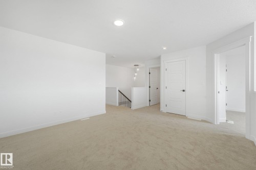 Carpeted flooring, contemporary interior doors, recessed lighting, and a modern stair railing with spindle balusters - 511 157 Avenue Ne, Edmonton, AB 