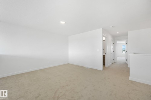 Spacious interior featuring neutral wall finishes, recessed ceiling lighting, and light-toned flooring throughout the open layout - 511 157 Avenue Ne, Edmonton, AB 