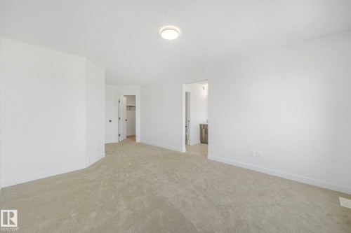 Neutral-toned carpet flooring, recessed lighting, and a walk-in closet with built-in shelving - 511 157 Avenue Ne, Edmonton, AB 