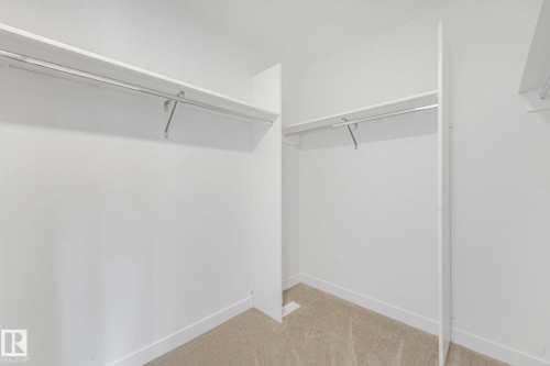 Built-in closet shelving with hanging rods and neutral carpet flooring - 511 157 Avenue Ne, Edmonton, AB 