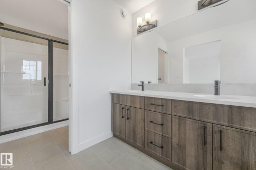 Dual vanity with wood-finish cabinetry and light-toned countertops - 511 157 Avenue Ne, Edmonton, AB 