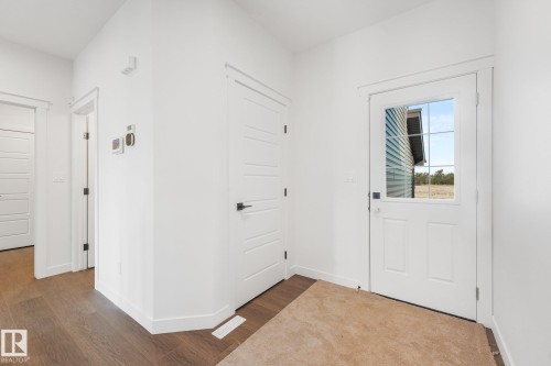 Wood-finish flooring, white paneled doors with black hardware, and a glass-paned door - 511 157 Avenue Ne, Edmonton, AB 