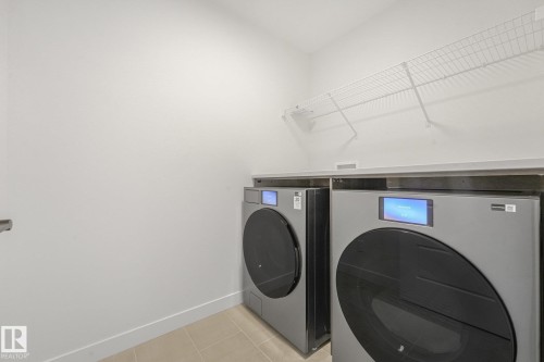 Laundry area featuring a wire shelf, light countertops, and tile flooring - 511 157 Avenue Ne, Edmonton, AB 