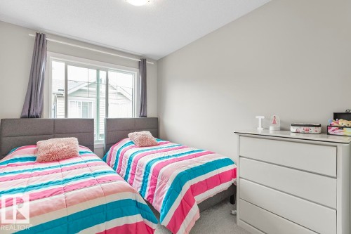 Room featuring a ceiling light fixture, window with drapes, and light gray wall paint - #22 3025 151 Av Nw, Edmonton, AB - Indoor Photo Showing Bedroom