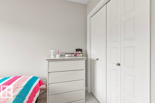 White six-panel bi-fold closet doors - #22 3025 151 Av Nw, Edmonton, AB - Indoor Photo Showing Bedroom