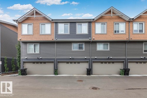 Multi-level townhouse exterior featuring horizontal siding and cedar shake accents - #22 3025 151 Av Nw, Edmonton, AB - Outdoor With Facade