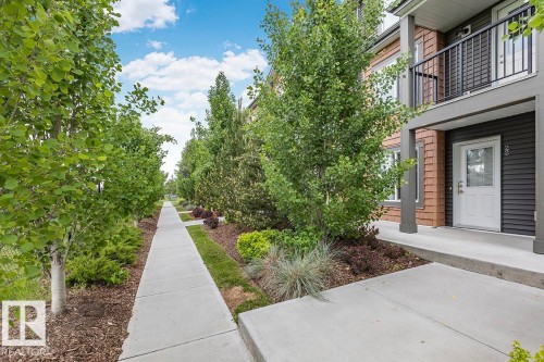 Townhome exterior featuring horizontal dark grey siding and brown shake accents - #22 3025 151 Av Nw, Edmonton, AB - Outdoor