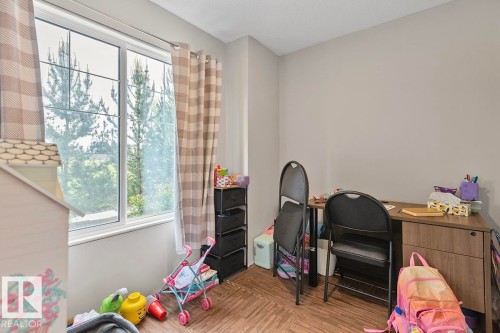 Bright room with a large window and wood-finish flooring - #22 3025 151 Av Nw, Edmonton, AB - Indoor
