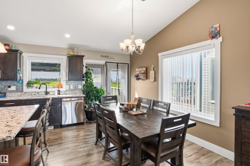 Open concept kitchen and dining area with wood-finish flooring, dark cabinetry, and light-toned countertops - 4927 57 Avenue, Cold Lake, AB 