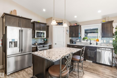 Chef's kitchen featuring stainless steel French-door refrigerator, gas range with stainless steel hood, and dishwasher - 4927 57 Avenue, Cold Lake, AB 