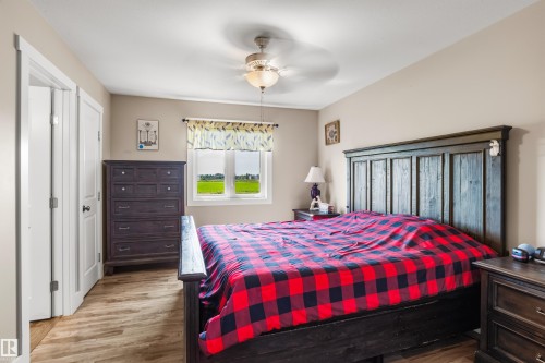 Wood-finish flooring, ceiling fan with integrated lighting, window with exterior scenery, paneled interior doors, and neutral wall tones - 4927 57 Avenue, Cold Lake, AB 
