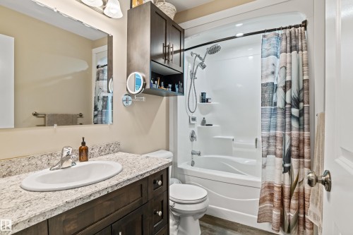 Bathroom featuring a single vanity with an integrated sink, light-toned countertop, and dark wood-finish cabinetry - 4927 57 Avenue, Cold Lake, AB 