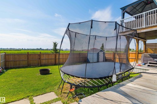 Expansive backyard featuring a wood-finish deck, privacy fencing, and a detached storage shed - 4927 57 Avenue, Cold Lake, AB 
