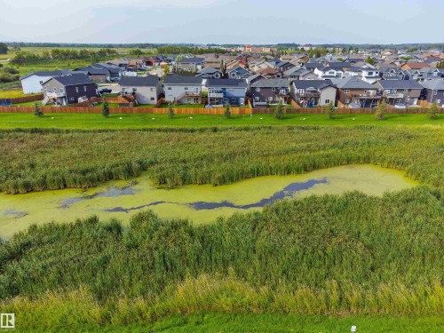 Expansive green space featuring a natural pond surrounded by dense vegetation - 4927 57 Avenue, Cold Lake, AB 