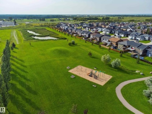 Expansive green space featuring a playground, paved walking path, and mature trees - 4927 57 Avenue, Cold Lake, AB 