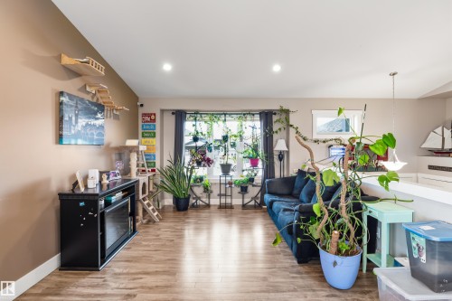 Recessed lighting, wood-finish flooring, ample natural light from a large window, neutral wall paint, and a built-in fireplace unit - 4927 57 Avenue, Cold Lake, AB 