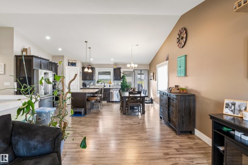 Wood-finish flooring throughout, vaulted ceiling, recessed lighting, dark wood cabinetry, and stainless steel appliances - 4927 57 Avenue, Cold Lake, AB 