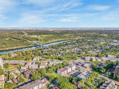 Expansive riverfront setting featuring a prominent bridge, lush green space, and a mix of urban and residential structures - 9347 105 Avenue Nw, Edmonton, AB 