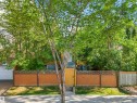 Private front yard featuring a wood gate, lattice fence, and mature trees - 9347 105 Avenue Nw, Edmonton, AB 