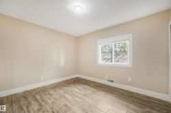 Wood-finish flooring, single window, white trim, recessed lighting, and neutral wall tones - 