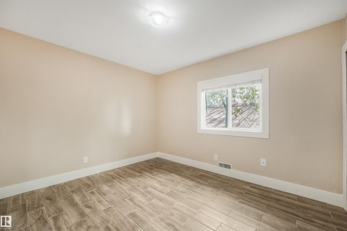 Wood-finish flooring, single window, white trim, recessed lighting, and neutral wall tones - 9347 105 Avenue Nw, Edmonton, AB 
