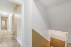 Hallway featuring wood-finish flooring, recessed lighting, and white trim - 