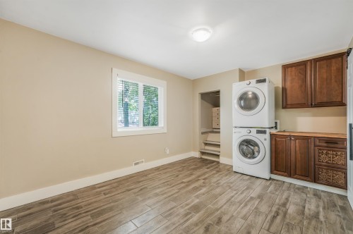 Wood-finish flooring, built-in cabinetry, and a stacked washer and dryer - 9347 105 Avenue Nw, Edmonton, AB 
