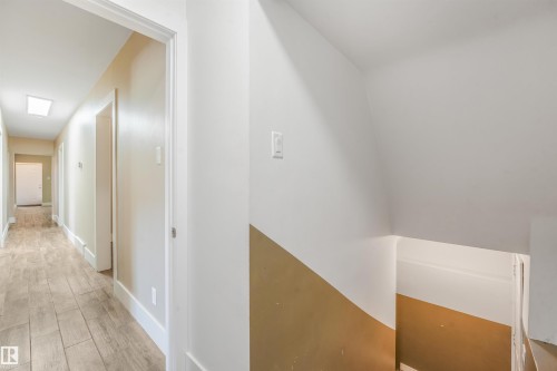 Hallway featuring wood-finish flooring, recessed lighting, and white trim - 9347 105 Avenue Nw, Edmonton, AB 