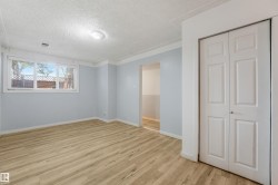 Wood-finish flooring, white bi-fold doors, and a single window with horizontal blinds - 