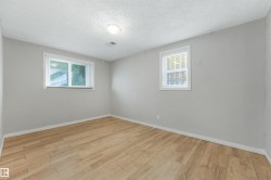 Neutral wall color, wood-finish flooring, two windows with blinds, and ceiling-mounted lighting fixture - 