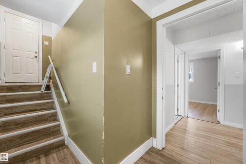 Wood-finish flooring throughout, featuring a staircase with coordinating wood-finish treads and white risers - 9347 105 Avenue Nw, Edmonton, AB 