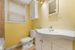 White vanity with integrated sink, chrome faucet, wall-mounted mirror, and tile flooring - 
