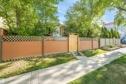 Privacy fence with lattice top, natural wood gate, and a concrete pathway - 