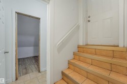 Tiled flooring and staircase with a white paneled door - 