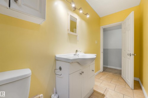 White vanity with integrated sink, track lighting, wall-mounted medicine cabinet, and tile flooring - 9347 105 Avenue Nw, Edmonton, AB 