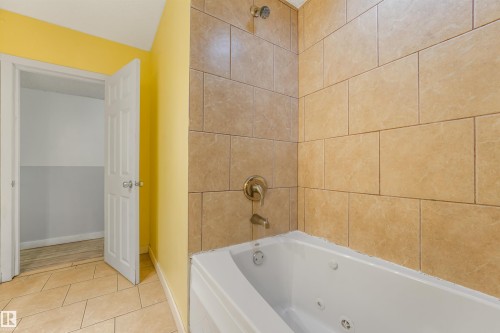Subway tile shower surround with a jetted soaking tub and bronze fixtures - 9347 105 Avenue Nw, Edmonton, AB 