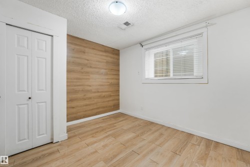 Wood-finish flooring, white walls, and a wood-panel accent wall - 9347 105 Avenue Nw, Edmonton, AB 