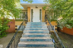 Concrete exterior staircase with wrought iron railings leading to a white entry door - 