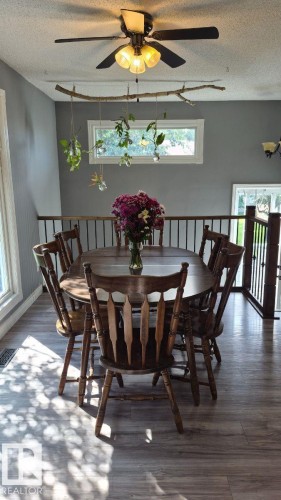 Wood-finish flooring with a ceiling fan light fixture and a light gray wall color - 5201 56A Street, Beaumont, AB 