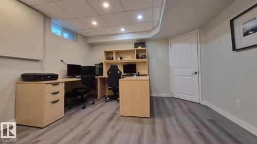 Wood-finish flooring with recessed lighting, light-colored walls, and a white interior door - 5201 56A Street, Beaumont, AB 