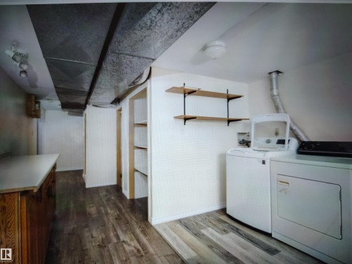 Laundry area featuring wood-finish flooring, built-in shelving, and open wall shelves - 11730 125 Street Nw, Edmonton, AB 
