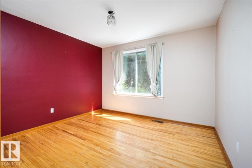Hardwood flooring, single window, chandelier fixture, and a red accent wall - 11730 125 Street Nw, Edmonton, AB 