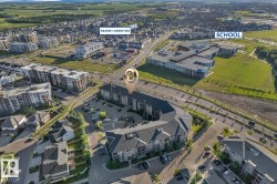 Expansive aerial overview of the community with a prominent multi-story residential building featuring a curved architectural design - 