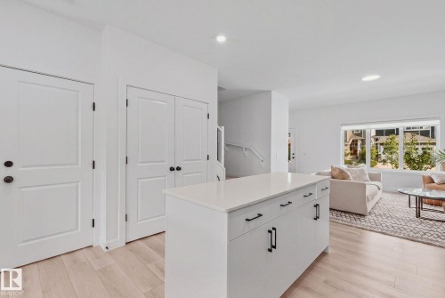 Kitchen island with a light-toned countertop, wood-finish flooring, and recessed lighting - 4023 Hawthorn Link Link Sw, Edmonton, AB 