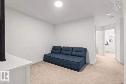 Recessed lighting illuminates the carpeted room, featuring crisp white walls and an open doorway - 4023 Hawthorn Link Link Sw, Edmonton, AB 